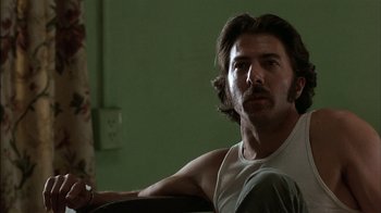 Movie still from “Straight Time” (1978), directed by Ulu Grosbard – A person sitting on a couch; Close Up shot, Low angle