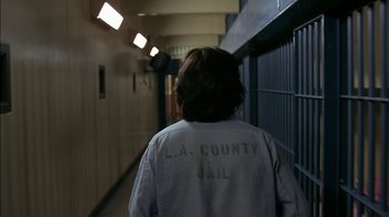 Movie still from “Straight Time” (1978), directed by Ulu Grosbard – A person walking down a hallway in a jail cell; Medium shot, High angle