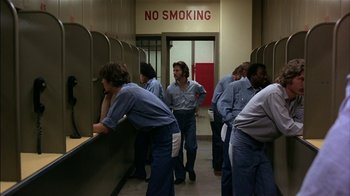 Movie still from “Straight Time” (1978), directed by Ulu Grosbard – A group of men standing in front of a counter; Wide shot, High angle
