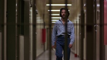 Movie still from “Straight Time” (1978), directed by Ulu Grosbard – A man walking down a hallway holding a cell phone; Wide shot, Low angle