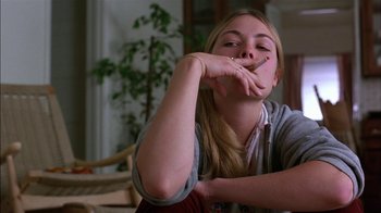 Movie still from “Straight Time” (1978), directed by Ulu Grosbard – A girl is smoking a cigarette while sitting on a couch; Close Up shot, Low angle