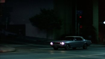 Movie still from “Straight Time” (1978), directed by Ulu Grosbard – A car driving down a street at night time; Wide shot, High angle