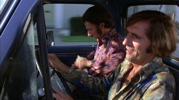 Movie still from “Straight Time” (1978), directed by Ulu Grosbard – Two men are driving in a car and one of the men is holding money in his hand; Medium shot, Low angle