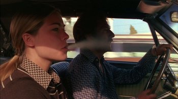 Movie still from “Straight Time” (1978), directed by Ulu Grosbard – A man and a woman driving a car in the road; Medium shot, Low angle