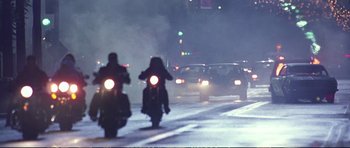 Movie still from “Strange Days” (1995), directed by Kathryn Bigelow – Two people on motorcycles driving down a street at night; Wide shot, Low angle