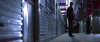 Movie still from “Strange Days” (1995), directed by Kathryn Bigelow – A man standing in front of a silver train; Wide shot, Low angle