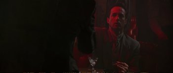 Movie still from “Strange Days” (1995), directed by Kathryn Bigelow – A man and woman sitting at a table in a dark room; Medium shot, Over the shoulder angle