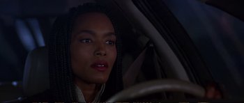 Movie still from “Strange Days” (1995), directed by Kathryn Bigelow – A woman sitting in the driver's seat of a car; Close Up shot, Over the shoulder angle