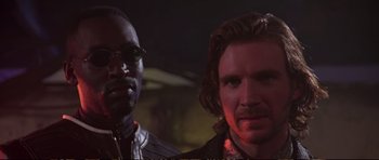 Movie still from “Strange Days” (1995), directed by Kathryn Bigelow – Two men standing next to each other in a dark room; Close Up shot, Low angle
