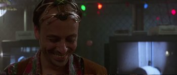 Movie still from “Strange Days” (1995), directed by Kathryn Bigelow – A man with a head piece smiling for the camera; Close Up shot, Over the shoulder angle