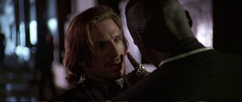 Movie still from “Strange Days” (1995), directed by Kathryn Bigelow – A man with a watch is talking to another man in a suit; Close Up shot, Over the shoulder angle