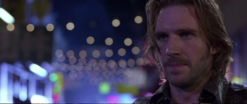 Movie still from “Strange Days” (1995), directed by Kathryn Bigelow – A person with a blurry background; Close Up shot, Over the shoulder angle