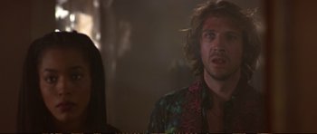 Movie still from “Strange Days” (1995), directed by Kathryn Bigelow – A man with long brown hair wearing a colorful shirt; Close Up shot, Over the shoulder angle
