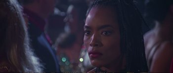 Movie still from “Strange Days” (1995), directed by Kathryn Bigelow – A woman's face in front of blurry lights; Close Up shot, Over the shoulder angle