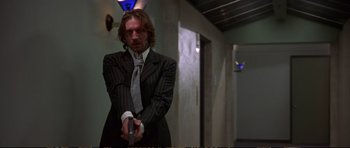 Movie still from “Strange Days” (1995), directed by Kathryn Bigelow – A man in a suit holding a knife in his hands; Medium shot, Low angle