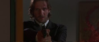 Movie still from “Strange Days” (1995), directed by Kathryn Bigelow – A man holding a gun while wearing a suit and tie; Close Up shot, Low angle