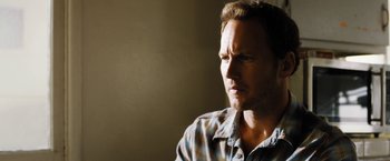 Movie still from “Stretch” (2014), directed by Joe Carnahan – A person wearing a plaid shirt; Close Up shot, Over the shoulder angle