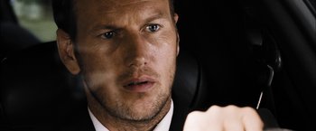 Movie still from “Stretch” (2014), directed by Joe Carnahan – A person wearing a suit and tie; Close Up shot, Low angle