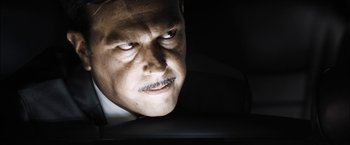 Movie still from “Stretch” (2014), directed by Joe Carnahan – A person wearing a suit and tie; Close Up shot, Low angle