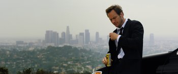Movie still from “Stretch” (2014), directed by Joe Carnahan – A man in a suit and tie holding a can of beer; Close Up shot, Low angle