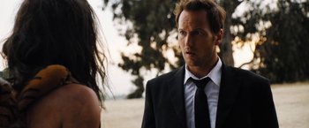 Movie still from “Stretch” (2014), directed by Joe Carnahan – A man in a suit and a tie standing next to a woman in a black dress; Close Up shot, Over the shoulder angle