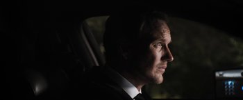 Movie still from “Stretch” (2014), directed by Joe Carnahan – A person wearing a suit and tie; Close Up shot, Over the shoulder angle