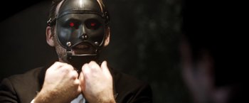 Movie still from “Stretch” (2014), directed by Joe Carnahan – A man wearing a black mask with red eyes; Close Up shot, Low angle