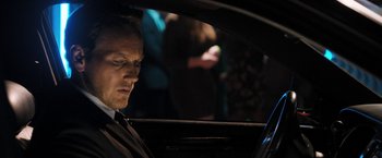 Movie still from “Stretch” (2014), directed by Joe Carnahan – A man sitting in the driver's seat of a car at night; Close Up shot, Over the shoulder angle