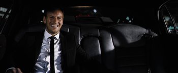 Movie still from “Stretch” (2014), directed by Joe Carnahan – A man sitting in the back of a limo; Medium shot, Over the shoulder angle