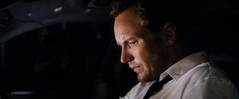 Movie still from “Stretch” (2014), directed by Joe Carnahan – A person wearing a shirt and tie; Close Up shot, Low angle