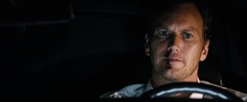 Movie still from “Stretch” (2014), directed by Joe Carnahan – A person driving a car in the dark; Close Up shot, Low angle