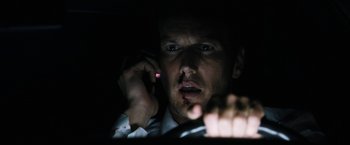 Movie still from “Stretch” (2014), directed by Joe Carnahan – A man is on his cell phone in the dark; Close Up shot, Low angle