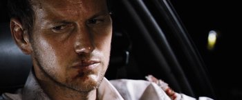 Movie still from “Stretch” (2014), directed by Joe Carnahan – A man's face covered in blood; Close Up shot, Over the shoulder angle