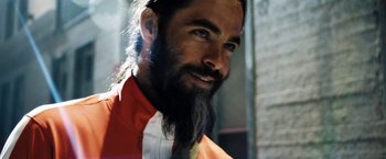 Movie still from “Stretch” (2014), directed by Joe Carnahan – A man with a long beard wearing an orange shirt; Close Up shot, Low angle