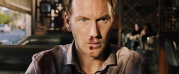 Movie still from “Stretch” (2014), directed by Joe Carnahan – A person with blood on his face; Close Up shot, Over the shoulder angle