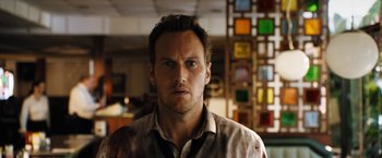 Movie still from “Stretch” (2014), directed by Joe Carnahan – A person wearing a button up shirt; Close Up shot, Over the shoulder angle