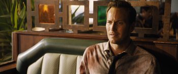 Movie still from “Stretch” (2014), directed by Joe Carnahan – A person sitting in front of a window; Close Up shot, Over the shoulder angle