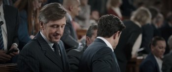 Movie still from “Suburra” (2015), directed by Stefano Sollima – A man in a suit and tie sitting next to another man in a suit and tie; Close Up shot, Over the shoulder angle