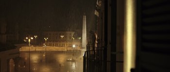 Movie still from “Suburra” (2015), directed by Stefano Sollima – A man standing in the rain next to a pole; Extreme Wide shot, Low angle
