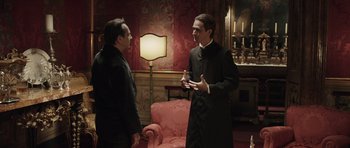 Movie still from “Suburra” (2015), directed by Stefano Sollima – Two men are talking in a living room; Medium shot, Over the shoulder angle