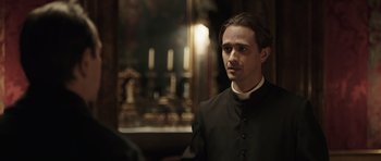 Movie still from “Suburra” (2015), directed by Stefano Sollima – A man wearing a black shirt and a black robe; Close Up shot, Over the shoulder angle