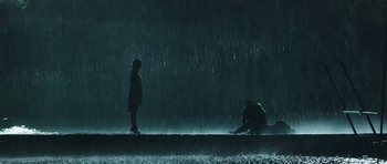 Movie still from “Suburra” (2015), directed by Stefano Sollima – Two people standing in the rain under an umbrella; Extreme Wide shot, Low angle