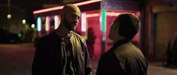 Movie still from “Suburra” (2015), directed by Stefano Sollima – A man with a bald head talking to another man; Medium shot, Over the shoulder angle