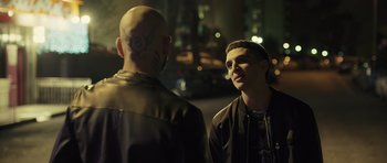 Movie still from “Suburra” (2015), directed by Stefano Sollima – Two men standing next to each other on the street; Medium shot, Over the shoulder angle