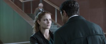 Movie still from “Suburra” (2015), directed by Stefano Sollima – A man and a woman standing next to each other in front of a staircase; Close Up shot, Over the shoulder angle