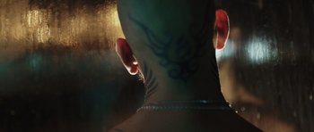 Movie still from “Suburra” (2015), directed by Stefano Sollima – A man with a tattoo on his neck and neck; Close Up shot, Over the shoulder angle