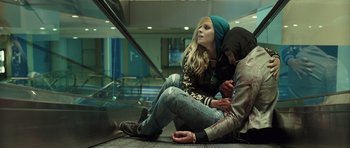 Movie still from “Suburra” (2015), directed by Stefano Sollima – A woman sitting on the ground next to a man; Medium shot, Low angle