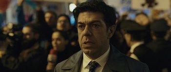 Movie still from “Suburra” (2015), directed by Stefano Sollima – A person wearing a suit and tie; Close Up shot, Low angle