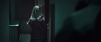 Movie still from “Suburra” (2015), directed by Stefano Sollima – A woman holding a video game controller in a dark room; Medium shot, Over the shoulder angle