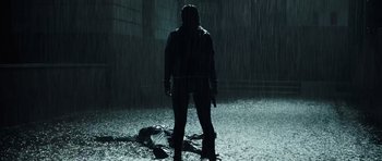 Movie still from “Suburra” (2015), directed by Stefano Sollima – A person standing in the rain holding a gun; Wide shot, Low angle